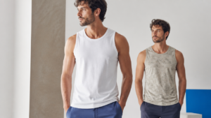 Homem usando regata branca masculina em ambiente clean, com foco em cores e estampas.